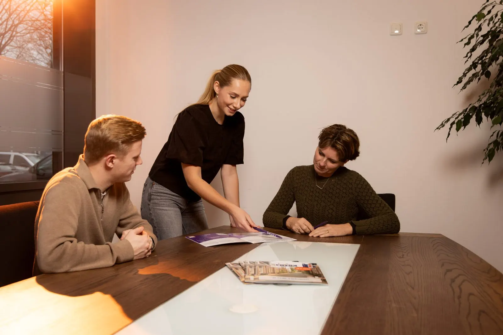 Drie collega's van FRYSK bekijken een brochure